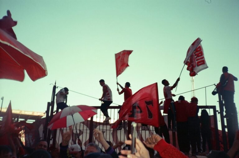 aficionados de independiente celebrando con banderas roja