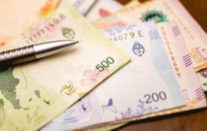 billetes argentinos y monedas sobre escritorio economico