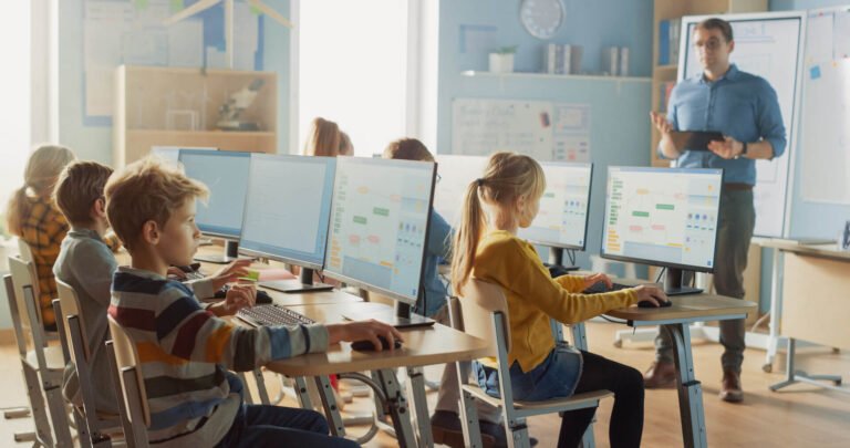 computadoras en aula con estudiantes aprendiendo