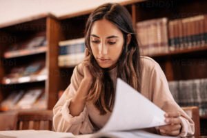 estudiante joven leyendo libros en biblioteca