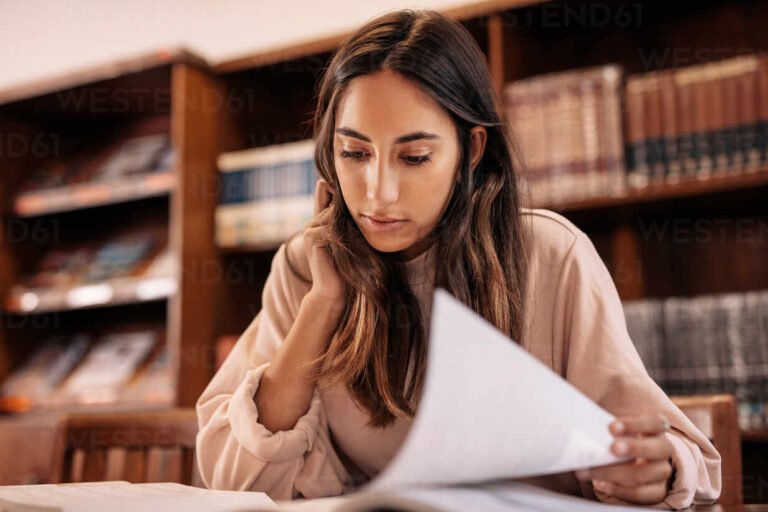 estudiante joven leyendo libros en biblioteca