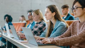 estudiante usando laptop en aula moderna