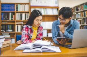 estudiantes universitarios consultando en biblioteca
