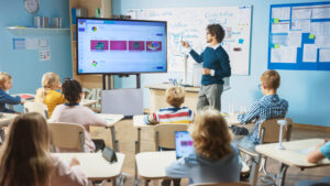 estudiantes y maestro en aula interactiva