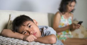 madre distante mirando a su hijo triste