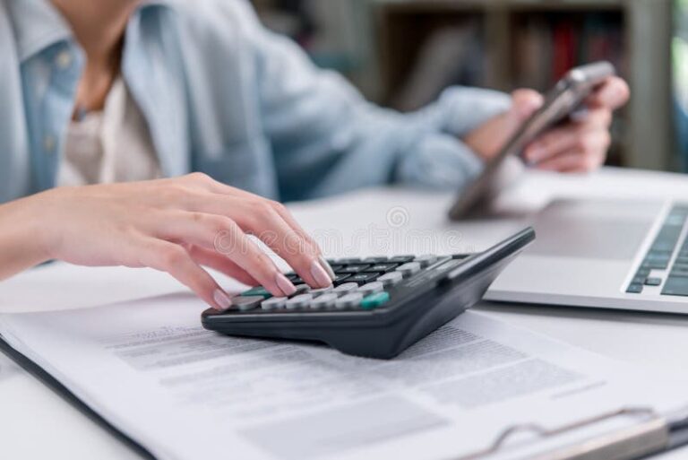 manos calculando impuestos con documentos financieros