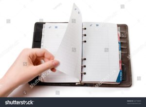 manos organizando libros y cuadernos abiertos