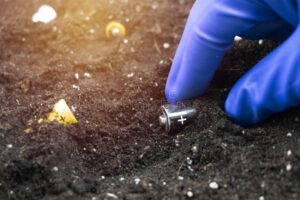 manos sosteniendo pilas usadas sobre tierra