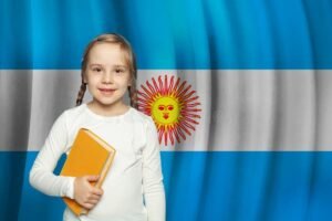 nino sonriente con libro y bandera argentina