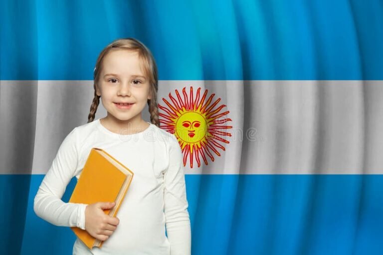 nino sonriente con libro y bandera argentina