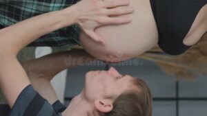 padre feliz acariciando la barriga de esposa
