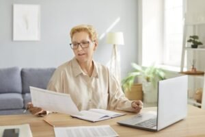 persona adulta mayor revisando documentos en escritorio