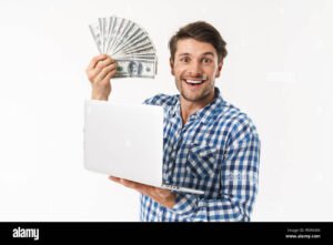 persona celebrando con billetes y laptop