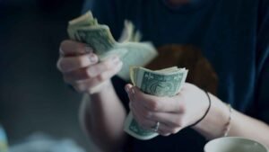 persona meditando con billetes y libros