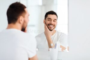 persona sonriente mirandose al espejo felizmente